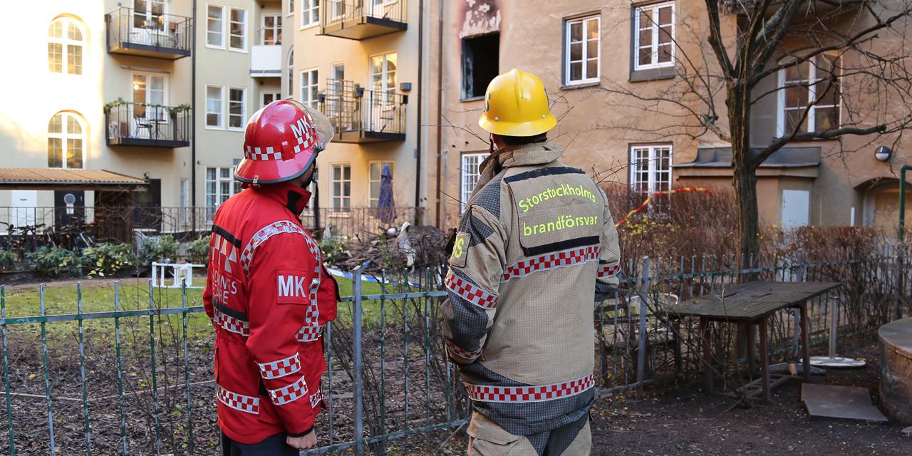 Räddningspersonal utanför en brandskadad lägenhet