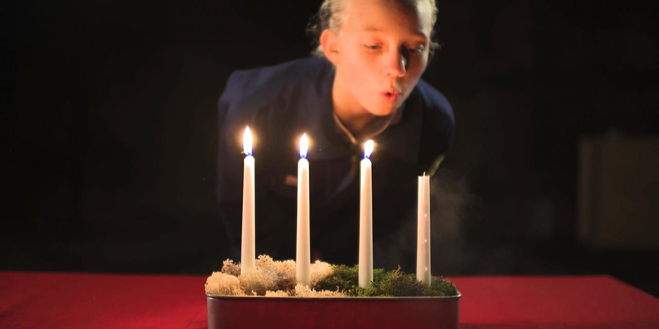 161201_Släck ljusen rädda julen_format2x1.jpg Flicka släcker stearinljus.
