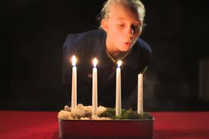 161201_Släck ljusen rädda julen_format3x2.jpg Flicka släcker stearinljus.